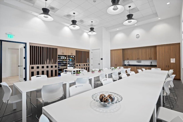 dining space featuring a towering ceiling and sink