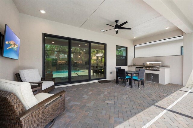 view of patio / terrace with ceiling fan, a grill, and exterior kitchen