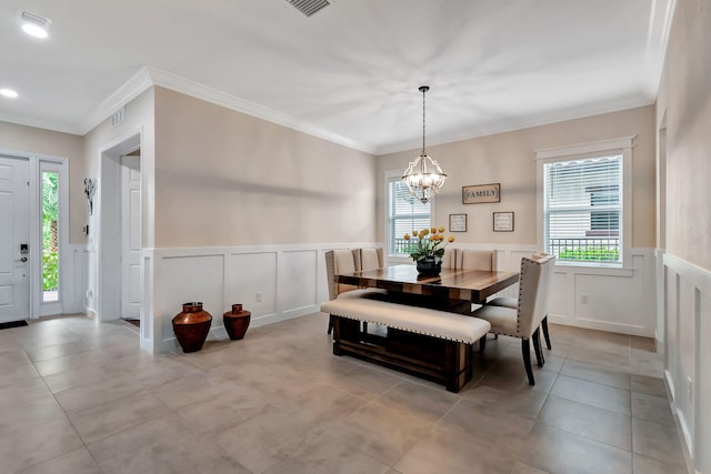 dining area with crown molding, plenty of natural light, and a chandelier