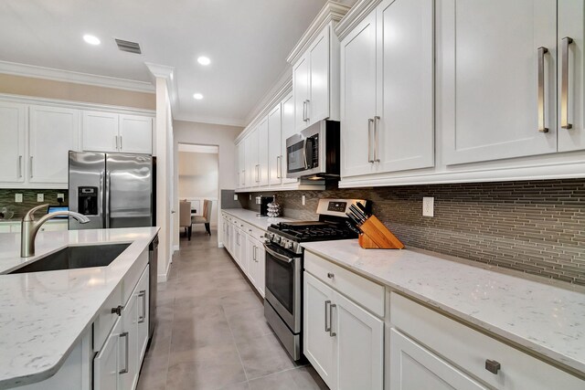 living area with light tile patterned floors, visible vents, and crown molding