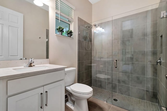 bathroom featuring tile patterned floors, vanity, toilet, and an enclosed shower