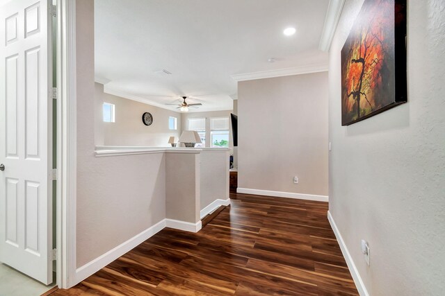 living room with ceiling fan, ornamental molding, dark wood-type flooring, and baseboards