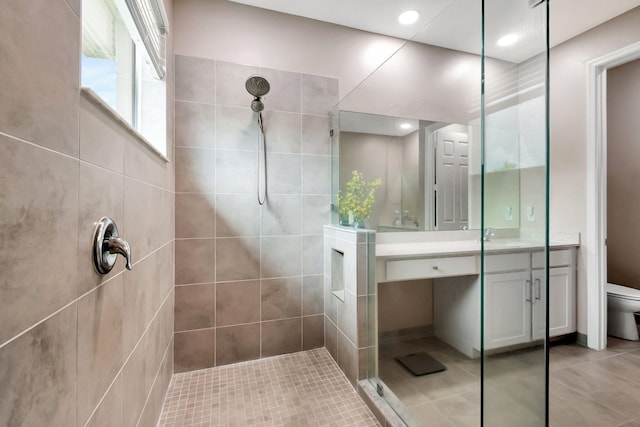 full bathroom featuring recessed lighting, toilet, vanity, a walk in shower, and tile patterned flooring