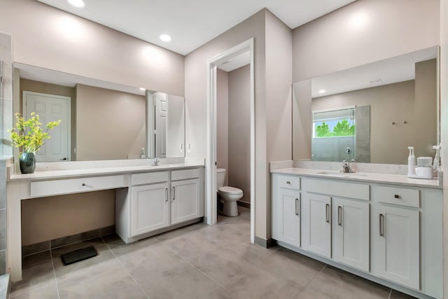 bathroom featuring toilet, two vanities, a sink, and tile patterned floors