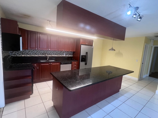 kitchen featuring backsplash, a center island, stainless steel appliances, sink, and dark stone counters