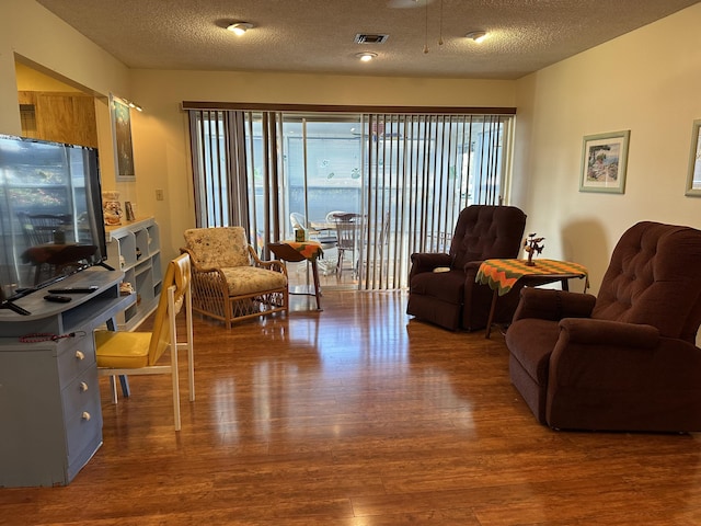 living room featuring a textured ceiling and hardwood / wood-style flooring