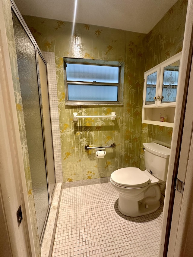 bathroom featuring tile patterned floors, toilet, and walk in shower