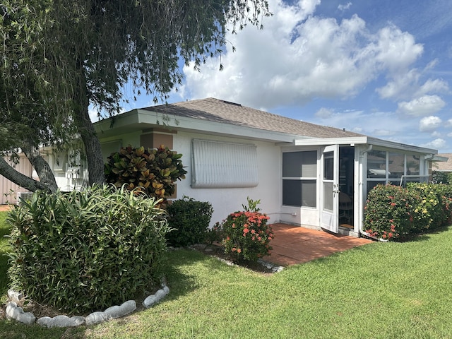 rear view of property featuring a yard and a sunroom