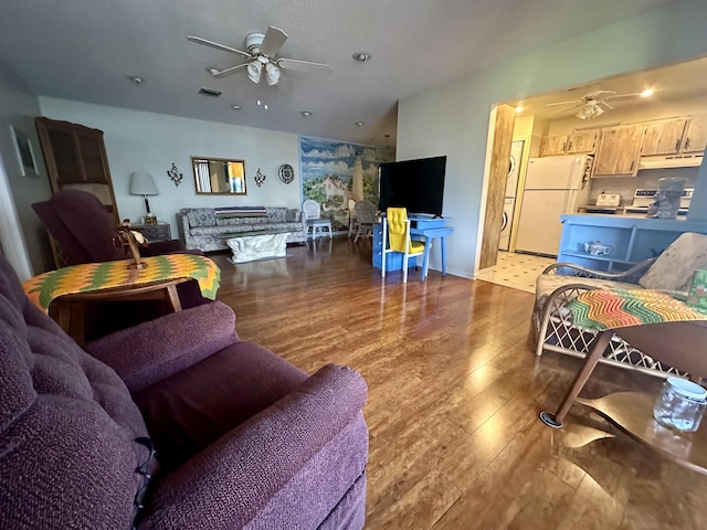 living room with ceiling fan and dark wood-type flooring