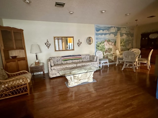 living room with a textured ceiling and dark hardwood / wood-style floors