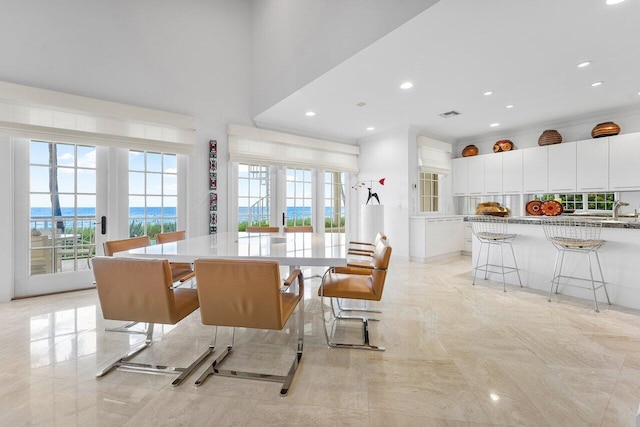 dining room with a towering ceiling, recessed lighting, and french doors