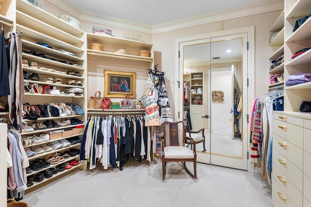 walk in closet featuring light carpet