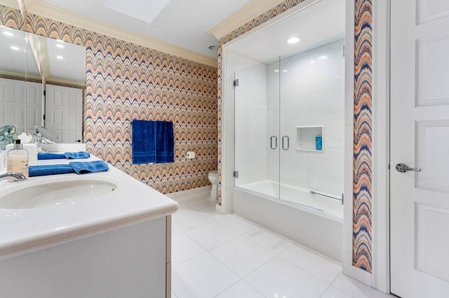 bathroom featuring crown molding, toilet, combined bath / shower with glass door, vanity, and tile patterned floors