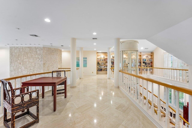 hall featuring decorative columns, visible vents, and recessed lighting