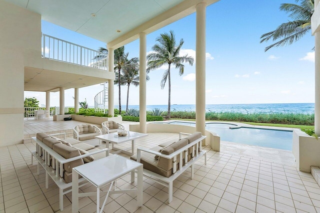 view of patio / terrace featuring a water view, a jacuzzi, outdoor lounge area, and stairs