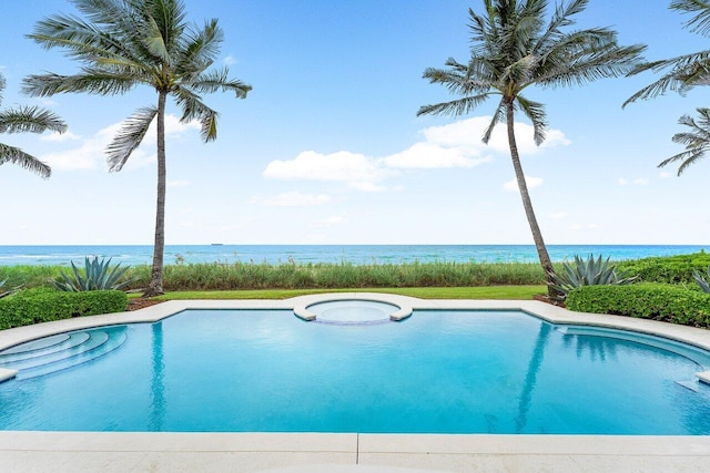 view of swimming pool featuring a pool with connected hot tub and a water view