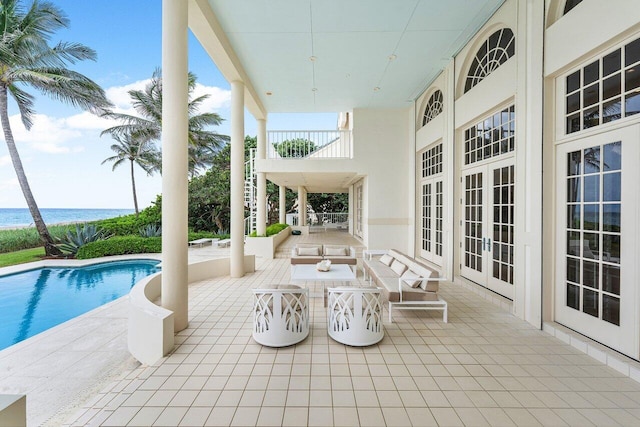 view of patio / terrace featuring stairs, french doors, a water view, and an outdoor pool