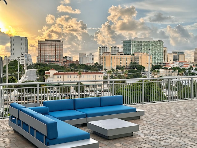 patio terrace at dusk featuring an outdoor living space and a balcony