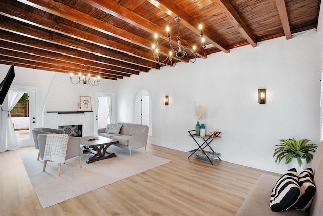 living room featuring wood ceiling, beam ceiling, a large fireplace, and light wood-type flooring