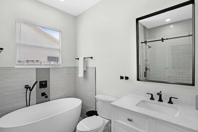 full bathroom with vanity, toilet, tile walls, and separate shower and tub