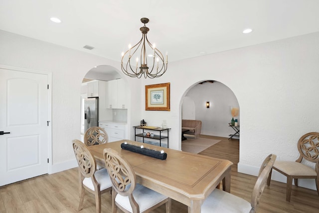 dining area featuring a notable chandelier and light wood-type flooring