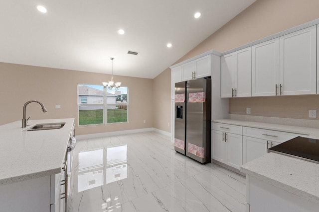 kitchen featuring a chandelier, sink, stainless steel refrigerator with ice dispenser, lofted ceiling, and white cabinets