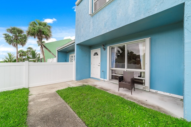 property entrance with a lawn