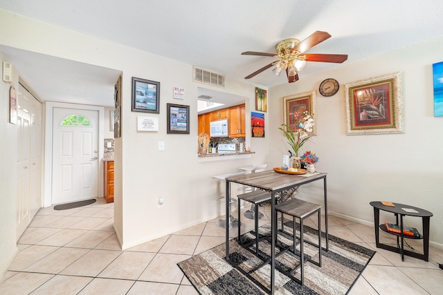 tiled dining space featuring ceiling fan