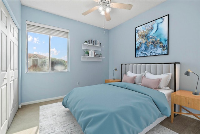 carpeted bedroom featuring ceiling fan and a closet