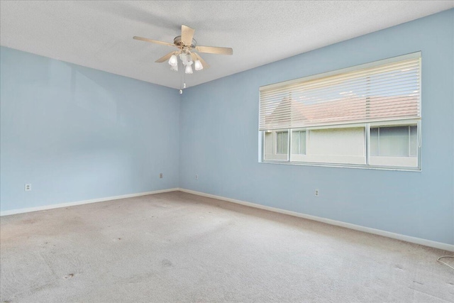 carpeted spare room featuring a textured ceiling and ceiling fan