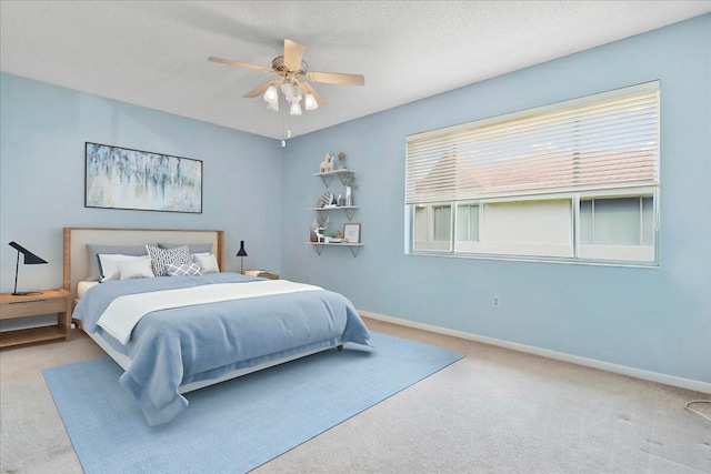 carpeted bedroom with a textured ceiling and ceiling fan