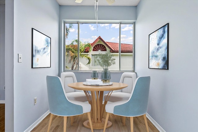 dining space with wood-type flooring and ceiling fan