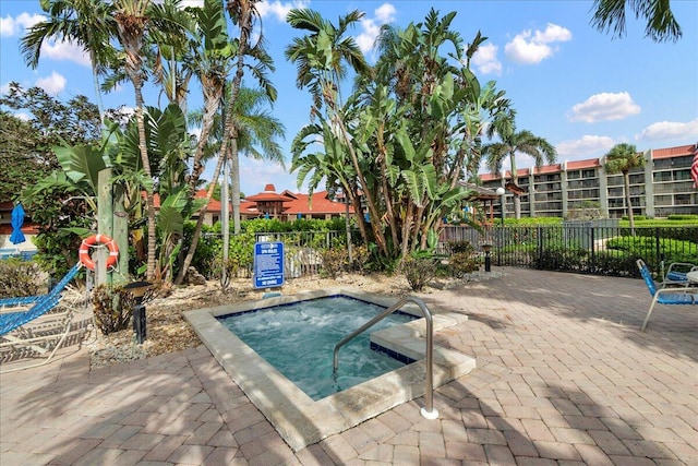 view of swimming pool featuring a hot tub and a patio