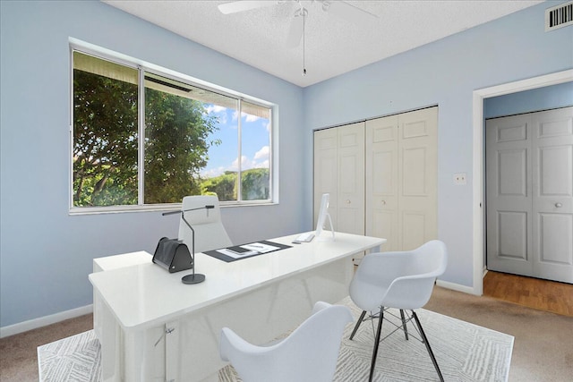 office area with ceiling fan, light colored carpet, and a textured ceiling