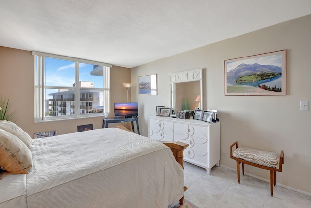 bedroom featuring light tile patterned floors and a textured ceiling