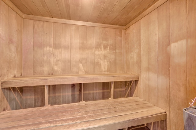 view of sauna featuring wooden ceiling and wooden walls