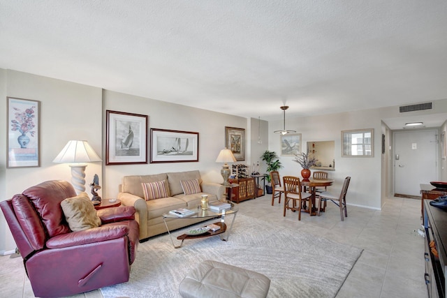 living room featuring a textured ceiling and light tile patterned flooring