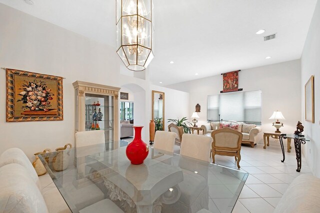 tiled living room with a notable chandelier