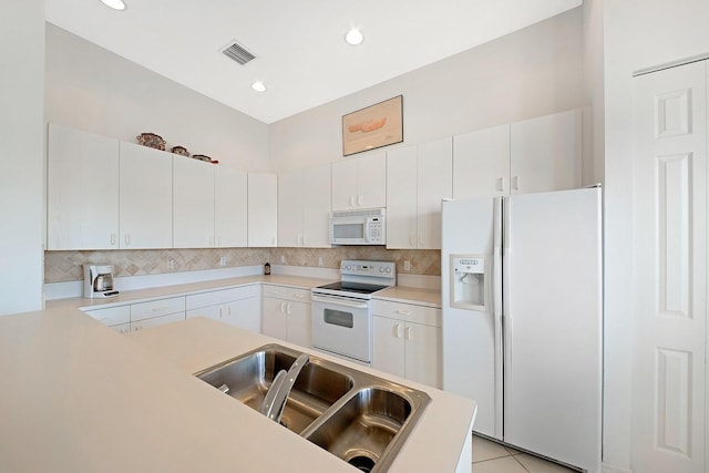 kitchen with white appliances, a sink, visible vents, and tasteful backsplash