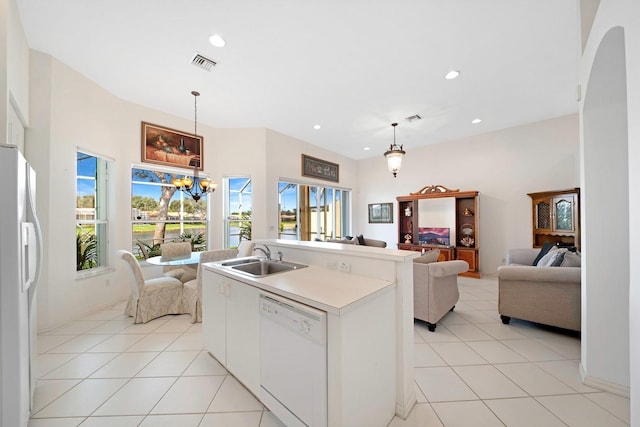 kitchen featuring light tile patterned flooring, white appliances, a sink, visible vents, and open floor plan