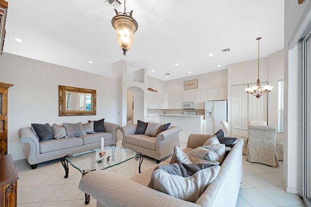 living area with visible vents, arched walkways, light tile patterned flooring, a notable chandelier, and recessed lighting