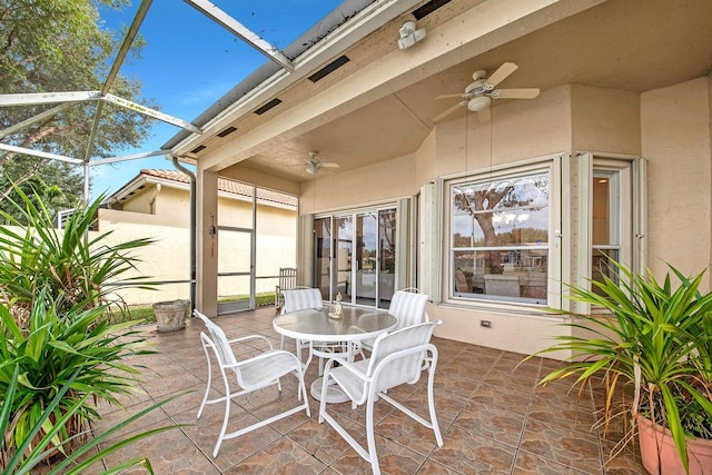 view of patio with glass enclosure and ceiling fan