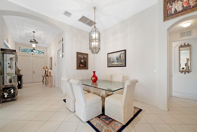 dining area with a chandelier, arched walkways, visible vents, and light tile patterned floors