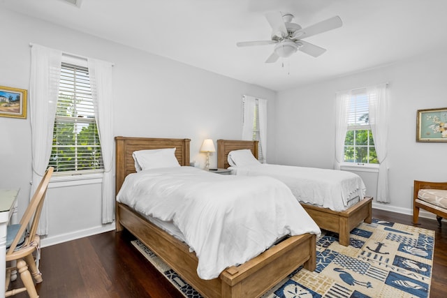 bedroom with multiple windows, ceiling fan, and dark wood-type flooring