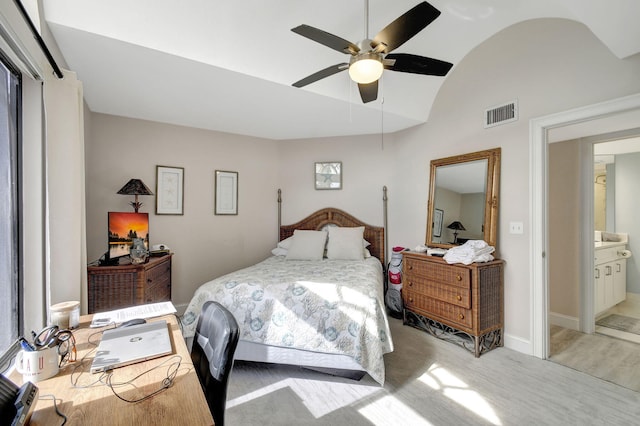 bedroom with ceiling fan, connected bathroom, and vaulted ceiling