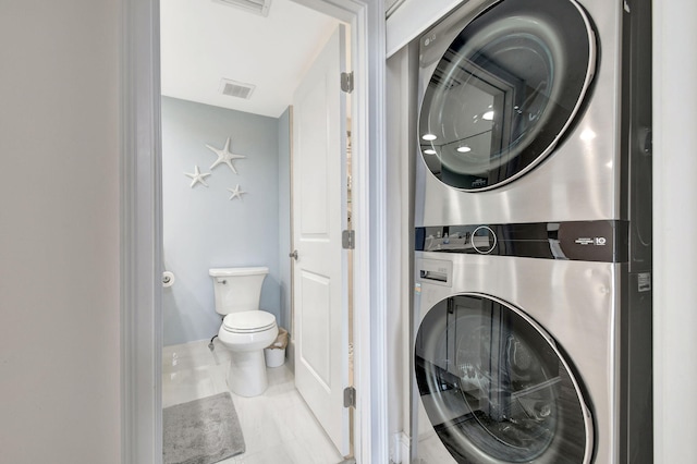 laundry room featuring tile patterned flooring and stacked washer and clothes dryer