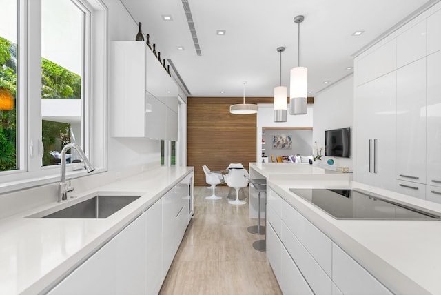 kitchen featuring light tile patterned floors, sink, decorative light fixtures, and white cabinetry