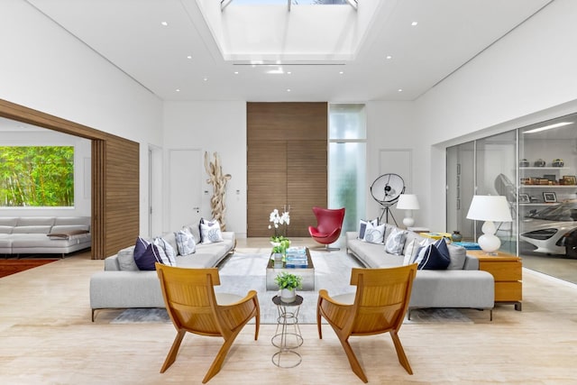 living room featuring a towering ceiling and light hardwood / wood-style floors