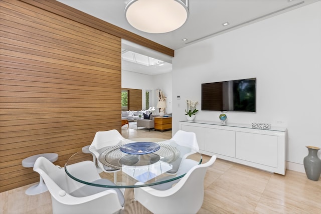 tiled dining area featuring wood walls