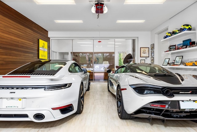 garage with wood walls and a garage door opener